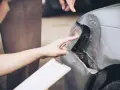 Dwóch mężczyzn ocenia szkody parkingowe na samochodzie. Jeden wskazuje palcem na uszkodzony reflektor, drugi trzyma dokumenty.
