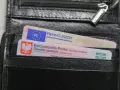 Czarny portfel z polskim dowodem osobistym i prawem jazdy. Widoczne oznaczenia dokumentów.
