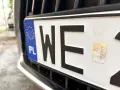 Zbliżenie na polską tablicę rejestracyjną z literami "WE". Zastanawiasz się, ile kosztują tablice rejestracyjne?