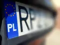 Zbliżenie na polskie rejestracje samochodowe z symbolem Unii Europejskiej. Litery "PL" i część numeru rejestracyjnego są wyraźne.
