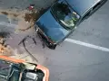 Wypadek samochodowy. Jeden samochód leży na dachu, drugi jest mocno uszkodzony. Widać ślady płynów i odłamków. To z pewnością szkoda całkowita, a nie naprawa.