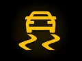Żółty symbol ESP na czarnym tle. Auto jedzie po śliskiej drodze, co oznacza, że system kontroli trakcji jest aktywny.