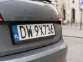 Polskie tablice rejestracyjne województwa z numerem DW-9X736 na szarym samochodzie.