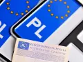 Polskie tablice rejestracyjne z symbolem PL i gwiazdkami UE oraz dokument "Pozwolenie Czasowe". Wymiary tablicy rejestracyjnej są standardowe.