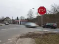Znak STOP i linia warunkowego zatrzymania na skrzyżowaniu. Samochody w ruchu.