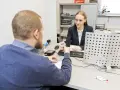 Mężczyzna przekazuje dokument urzędniczce, kiedy wymiana prawa jazdy jest w toku.