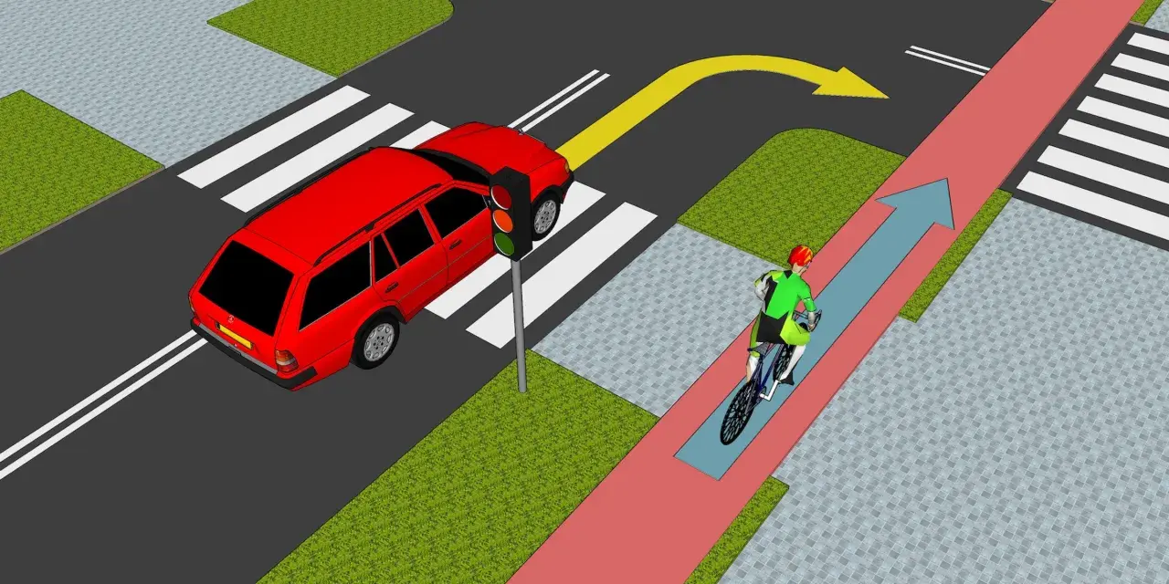 Rowerzysta jedzie ścieżką rowerową, a samochód czeka na zielone światło. Zasada chodnika jest jasna: piesi mają pierwszeństwo na pasach.