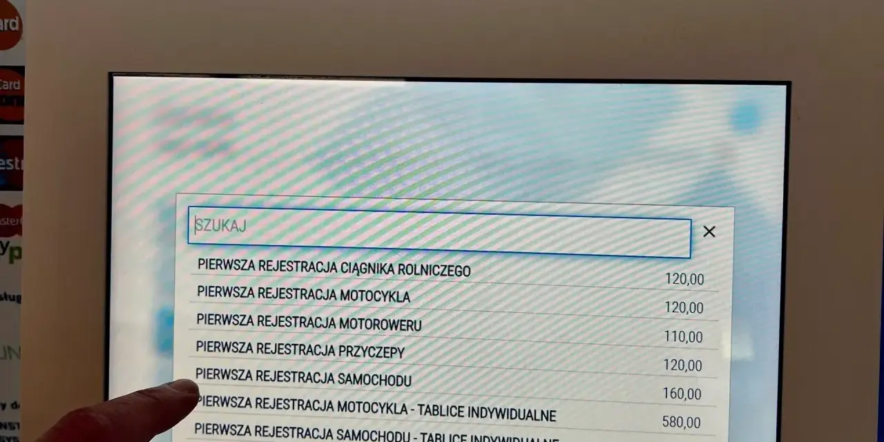 Palec wskazuje opcję "PIERWSZA REJESTRACJA SAMOCHODU" na ekranie, gdzie szukamy informacji, jak napisać upoważnienie do wyrejestrowania samochodu.