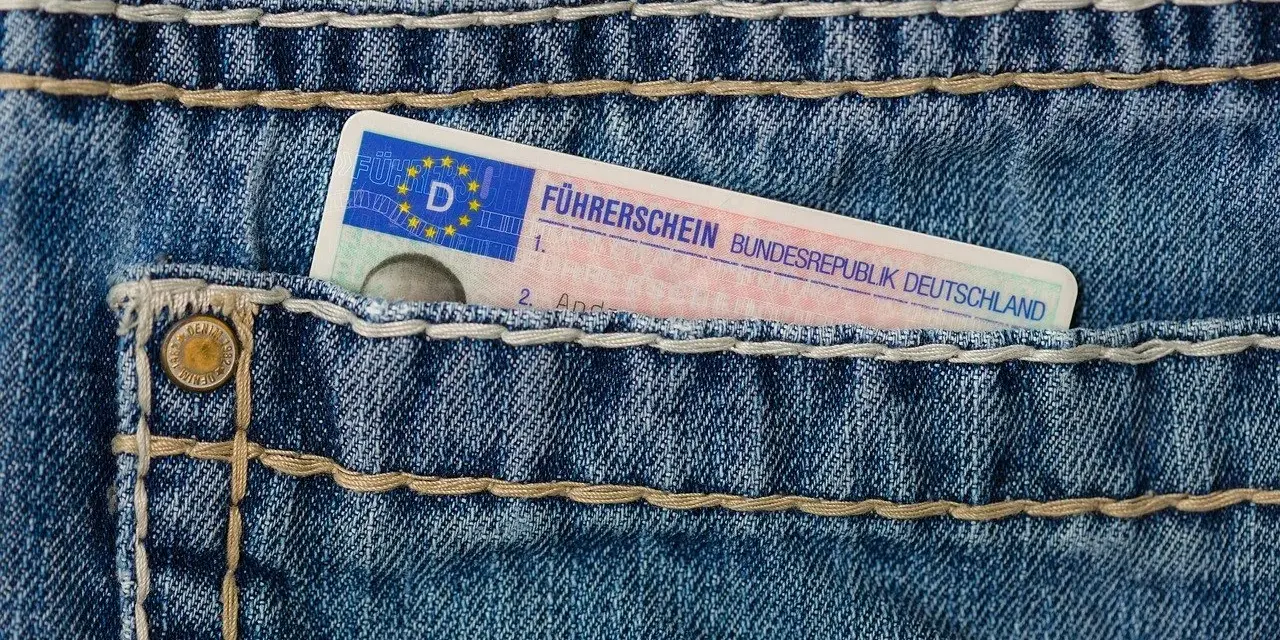 Niebieskie jeansy z kieszenią, w której widać fragment niemieckiego prawa jazdy. Brak karty pojazdu.