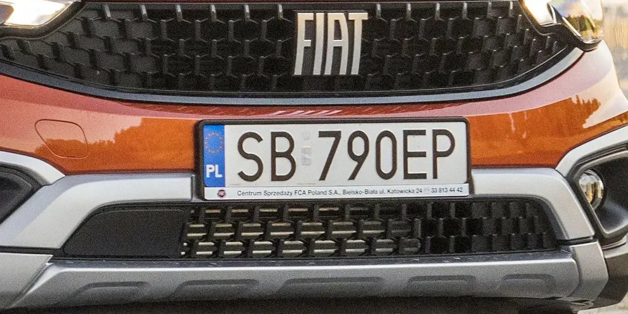 Pomarańczowy Fiat z tablicą rejestracyjną SB 790EP.
