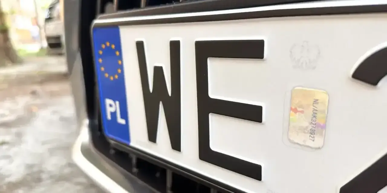 Zbliżenie na polską tablicę rejestracyjną z literami "WE". Zastanawiasz się, ile kosztują tablice rejestracyjne?