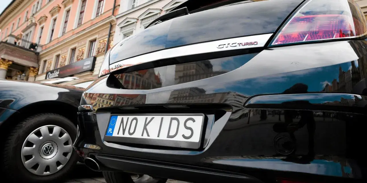 Czarne auto z indywidualnymi tablicami rejestracyjnymi "NO KIDS". Przykłady takich tablic pokazują kreatywność kierowców.