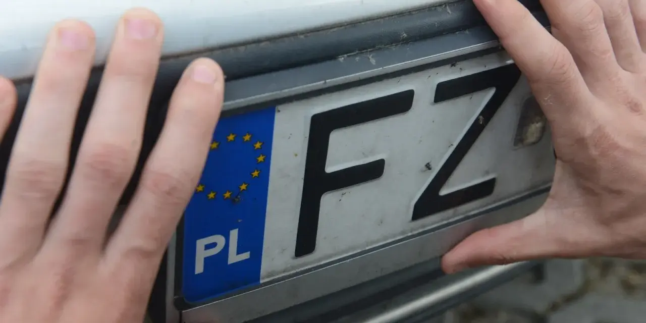 Dłonie trzymają tablicę rejestracyjną z literami FZ i symbolem Unii Europejskiej. Jaka to rejestracja?