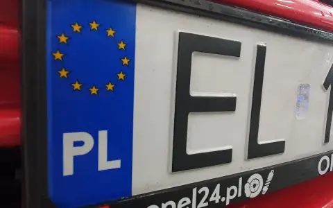 Tablica rejestracyjna samochodu z oznaczeniem PL i gwiazdkami UE. Litery EL i cyfry 1.