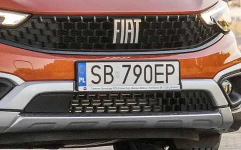 Pomarańczowy Fiat z tablicą rejestracyjną SB 790EP.