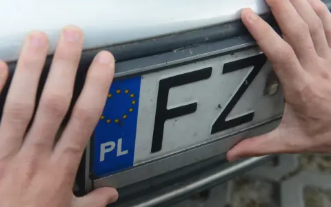 Dłonie trzymają tablicę rejestracyjną z literami FZ. Czy to rejestracja KT, jakie miasto?