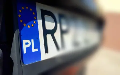 Zbliżenie na polskie rejestracje samochodowe z symbolem Unii Europejskiej. Litery "PL" i część numeru rejestracyjnego są wyraźne.