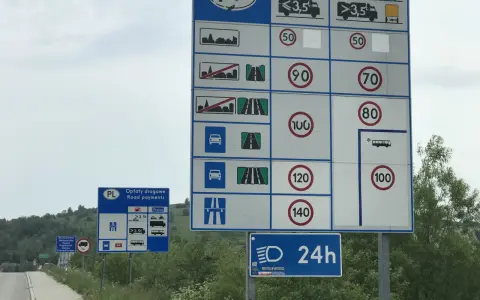 Znaki drogowe informują o opłatach i limitach prędkości na drodze ekspresowej. Maksymalna dozwolona prędkość dla samochodów osobowych to 140 km/h.