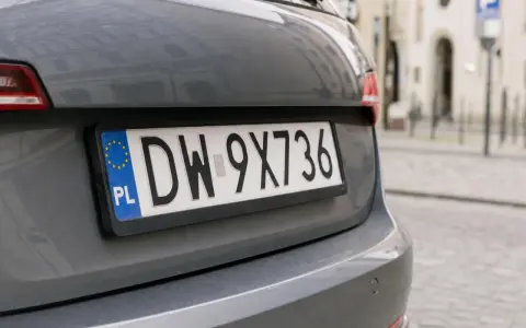 Polskie tablice rejestracyjne województwa z numerem DW-9X736 na szarym samochodzie.