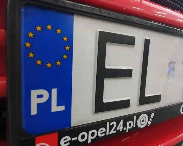 Tablica rejestracyjna samochodu z oznaczeniem PL i gwiazdkami UE. Litery EL i cyfry 1.