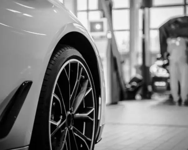 Wniosek o utratę wartości pojazdu wzór. Nowoczesny samochód w warsztacie, mechanik pracuje przy silniku.