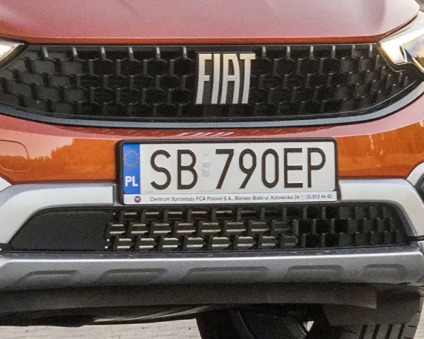 Pomarańczowy Fiat z tablicą rejestracyjną SB 790EP.