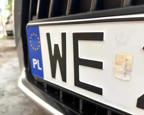 Zbliżenie na polską tablicę rejestracyjną z literami "WE". Zastanawiasz się, ile kosztują tablice rejestracyjne?
