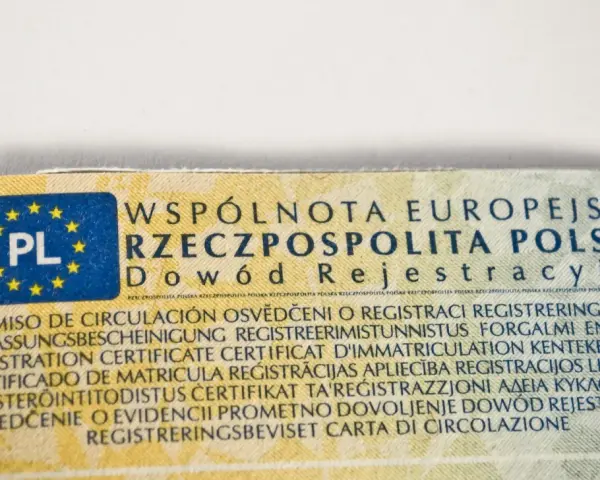 Fragment dowodu rejestracyjnego z oznaczeniem PL i tekstem w wielu językach, w tym "Dowód Rejestracyjny".