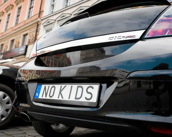 Czarne auto z indywidualnymi tablicami rejestracyjnymi "NO KIDS". Przykłady takich tablic pokazują kreatywność kierowców.
