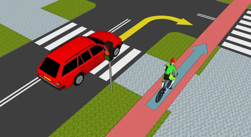 Rowerzysta jedzie ścieżką rowerową, a samochód czeka na zielone światło. Zasada chodnika jest jasna: piesi mają pierwszeństwo na pasach.