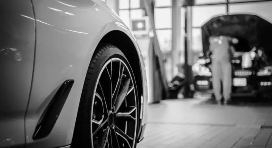 Wniosek o utratę wartości pojazdu wzór. Nowoczesny samochód w warsztacie, mechanik pracuje przy silniku.