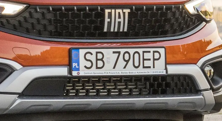 Pomarańczowy Fiat z tablicą rejestracyjną SB 790EP.