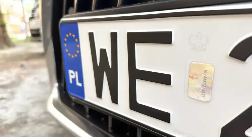 Zbliżenie na polską tablicę rejestracyjną z literami "WE". Zastanawiasz się, ile kosztują tablice rejestracyjne?