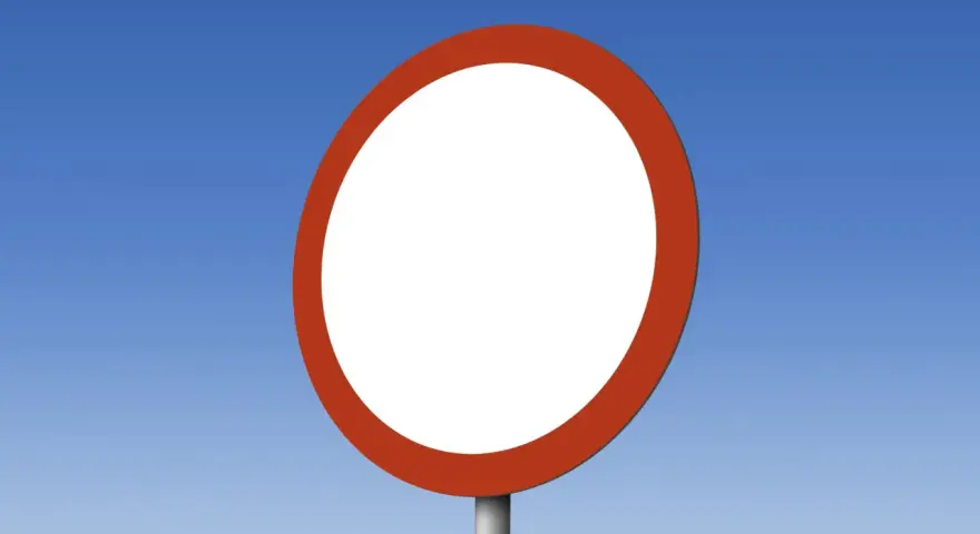 Okrągły, biały znak drogowy b1 z czerwoną obwódką na tle błękitnego nieba.