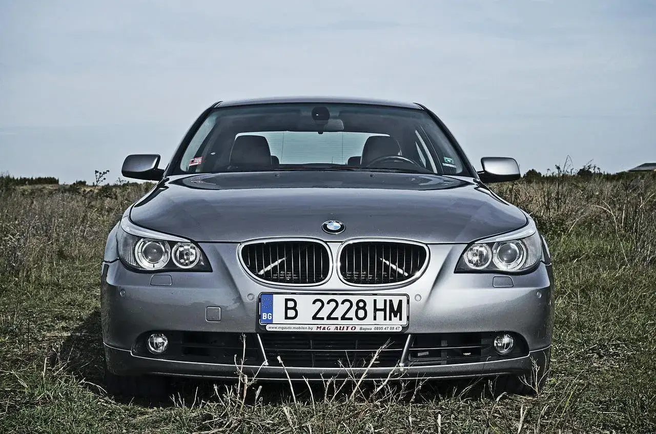 Szara limuzyna BMW z tablicą rejestracyjną B 2228 HM. Standardowe wymiary tablicy rejestracyjnej są widoczne na zderzaku.