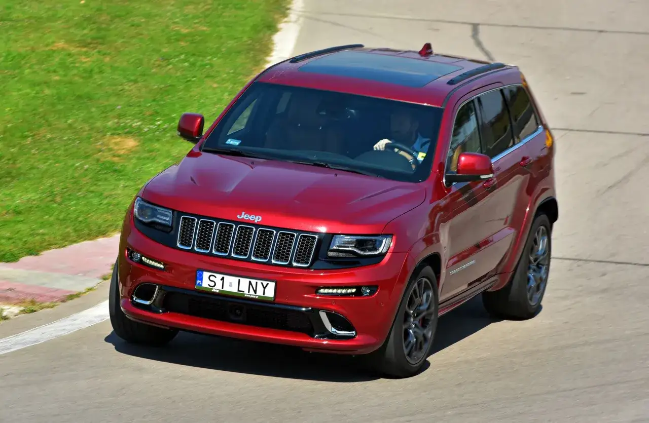 Czerwony Jeep Grand Cherokee na torze. Tablica rejestracyjna S1 LNY to ciekawe indywidualne tablice rejestracyjne przykłady.