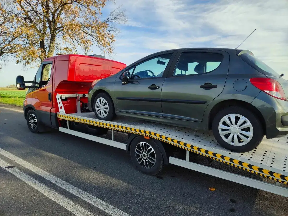 Ciemnoszary samochód osobowy na lawecie, przygotowany do transportu. Konfiskata samochodu stała się faktem.
