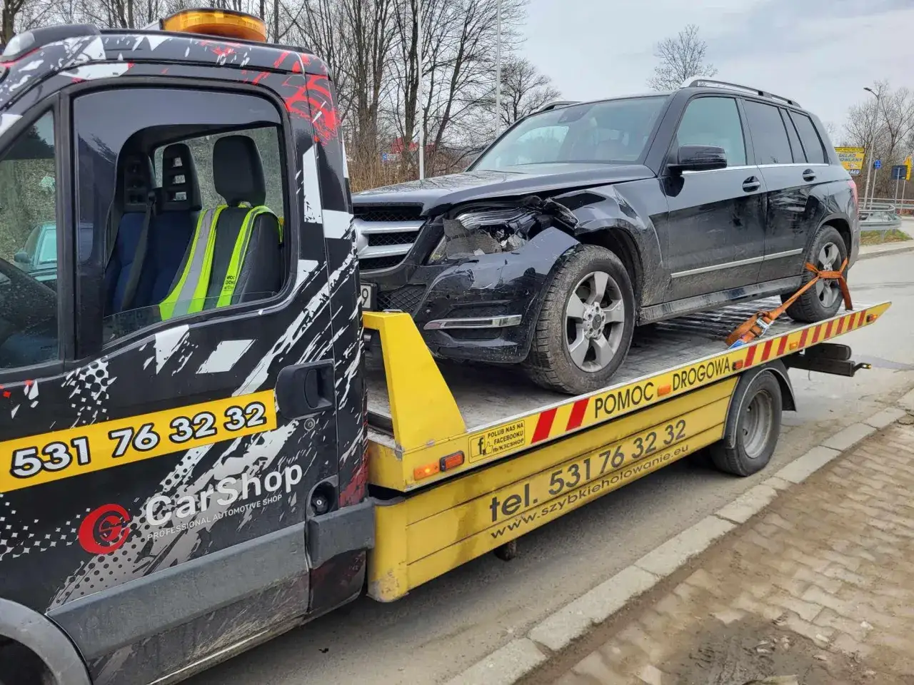 Uszkodzony czarny SUV na lawecie. Potrzebna pomoc drogowa, nawet na 1500 km. Dzwon na 531 76 32 32.