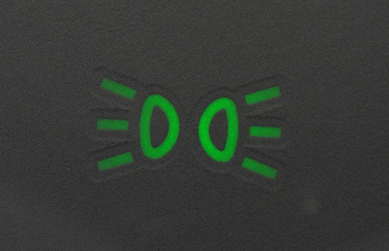Zielony symbol świateł mijania na ciemnym tle.