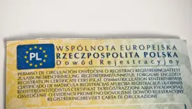 Fragment dowodu rejestracyjnego z oznaczeniem PL i tekstem w wielu językach, w tym "Dowód Rejestracyjny".